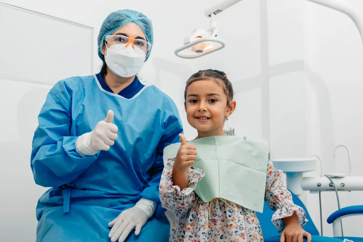Dentiste et jeune patiente souriantes après un contrôle