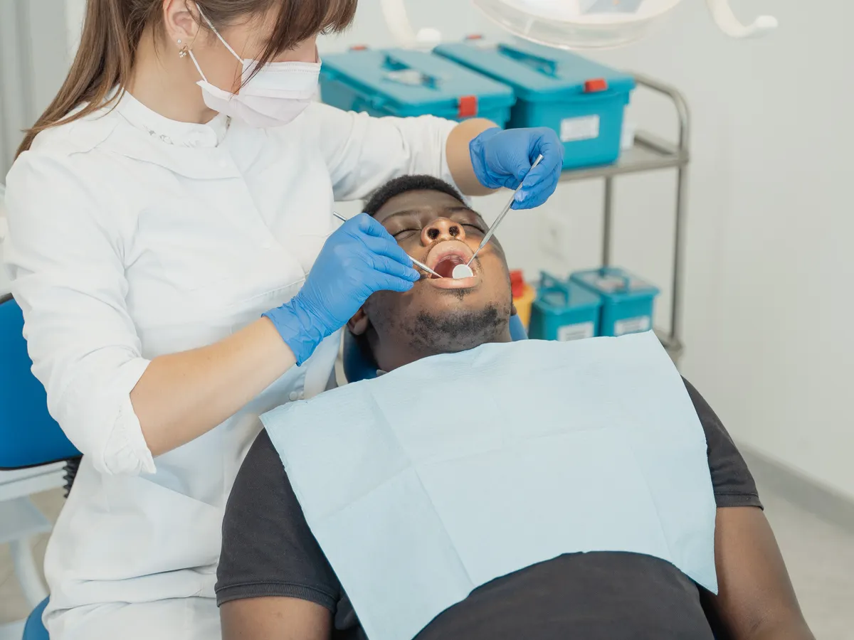 Dentiste réalisant un soin dentaire sur un patient