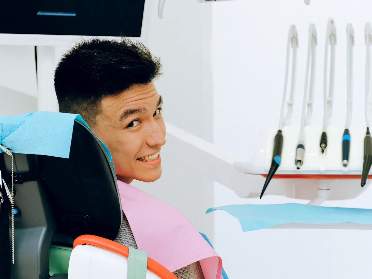 Patient souriant installé dans le fauteuil dentaire