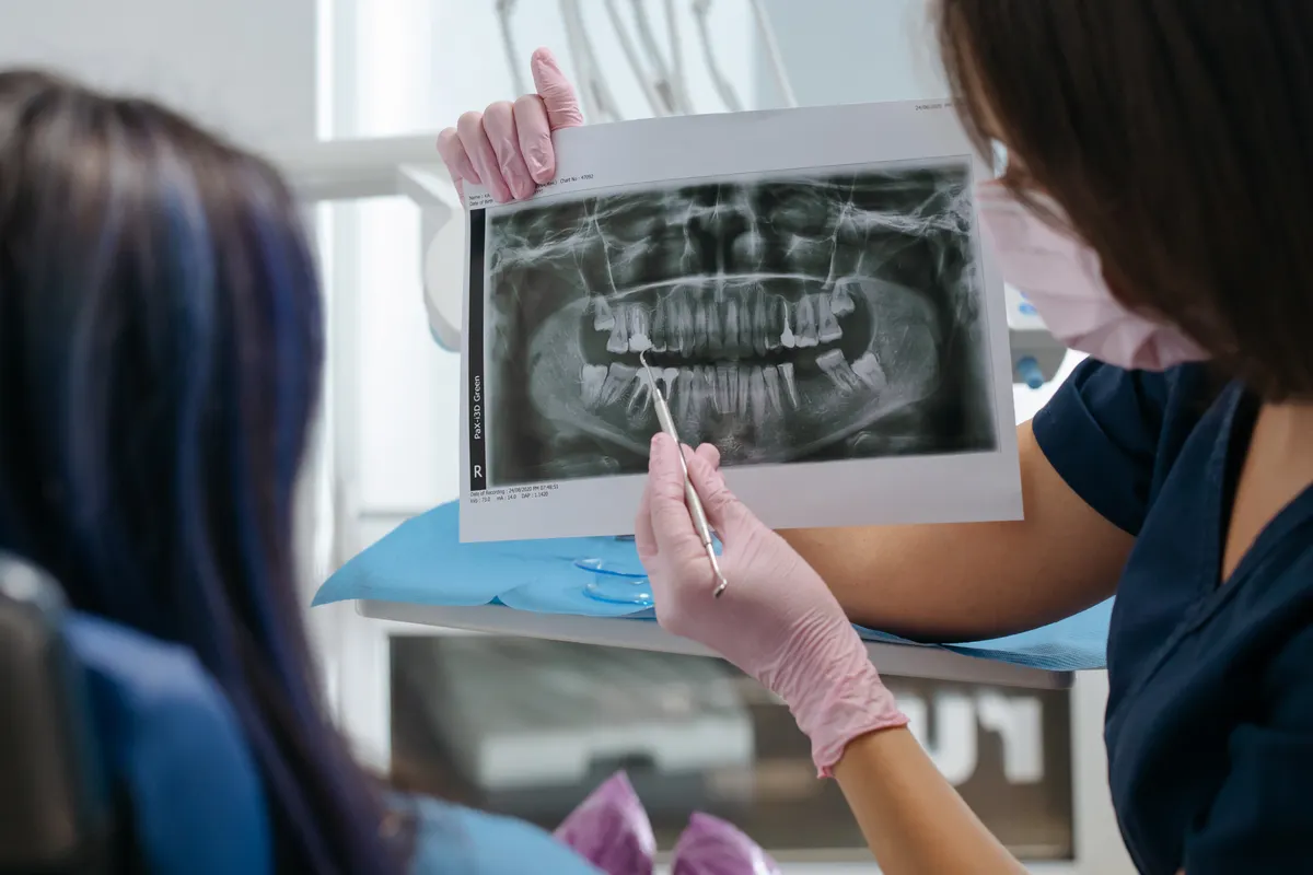 Dentiste montrant une radiographie dentaire à une patiente